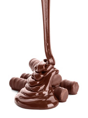 Pouring of melted chocolate on sweet candies against white background