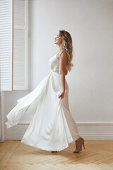 Beautiful slender woman in white wedding dress, new collection of dresses for the bride. Noise, out of focus
