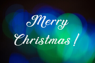 Merry christmas text on abstract blue and green lights bokeh background