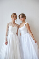 Two Beautiful slender woman in white wedding dress, new collection of dresses for the bride. Noise, out of focus