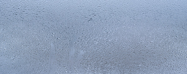 Window with water drops closeup, inside, selective focus. Window with condensate or steam after heavy rain, large texture or background