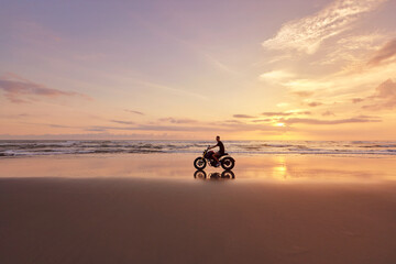 Man And Motorcycle On Ocean Beach At Beautiful Tropical Sunset. Biker’s Silhouette On Motorbike...