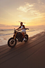Man And Motorcycle On Ocean Beach At Beautiful Tropical Sunset. Handsome Biker On Motorbike On Sandy Coast In Bali, Indonesia.