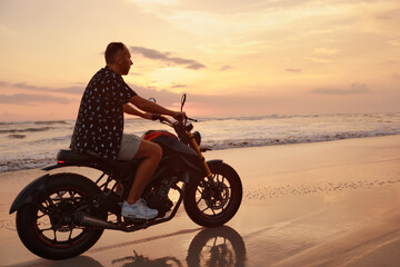 Man And Motorcycle On Ocean Beach At Beautiful Tropical Sunset. Handsome Biker On Motorbike On Sandy Coast In Bali, Indonesia.