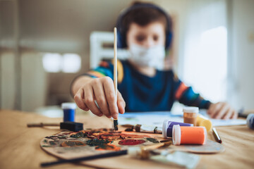 Fototapeta premium Cute little boy painting a picture in home studio