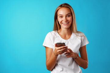 Young blonde casual girl using her smartphone.