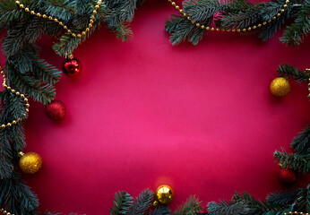 Fototapeta na wymiar Christmas ornament made of green spruce with red and gold balls and beads in the form of frame