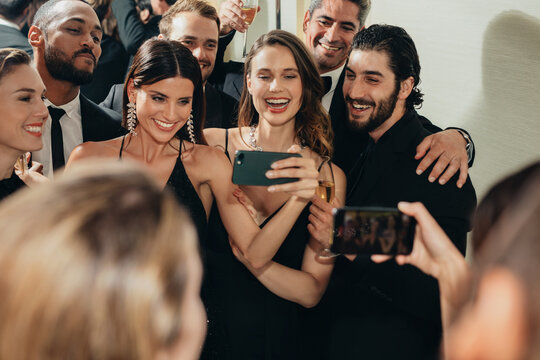 Beautiful woman taking selfies with his friends at a party