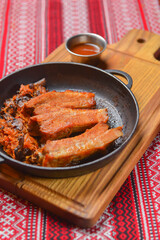 Delicious dinner and clean eating concept from above. Fried meat in a pan, on vintage background flat-lay.