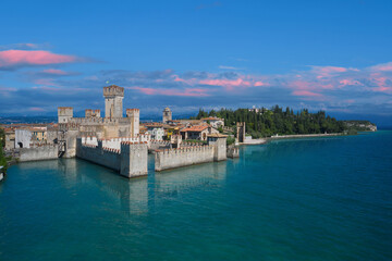 Fototapeta na wymiar Scaligero Castle in Sirmione, sunrise, pink clouds . Aerial view on Sirmione sul Garda. Italy, Lombardy.Tourist destination in Lombardy region of Italy. Aerial photography with drone.