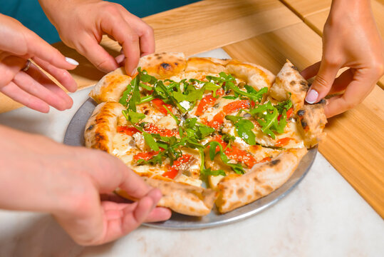 Image of friends hands taking slices of pizza. Top view, flat lay. Italian cuisine concept, eating delicious pizza.