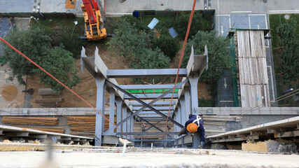 Naklejka premium Workers install steel structures at construction sites