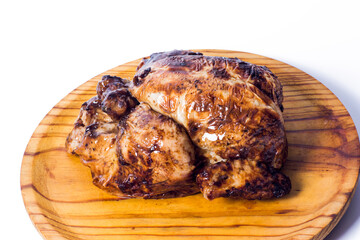 Tasty roast chicken on a wooden tray on white background