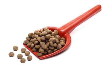 Dog food, dry granules for puppies in plastic shovel, spoon isolated on white background