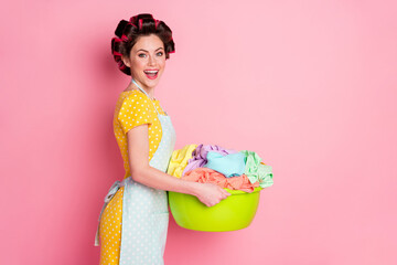 Profile side photo of positive girl hold basin dirty clothes laundry wear yellow skirt isolated on pastel color background