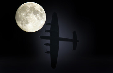 Silhouetted Lancaster bomber and moon composite. British second world war heavy bomber.