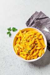 Mac and cheese in white bowl, gray background, top view, copy space. Cheese pasta in bowl.