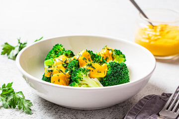 Broccoli with cheese sauce in white bowl. Healthy food concept.