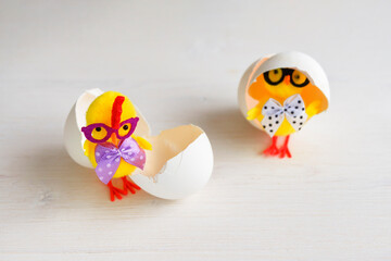 Two chicks with eggshells. Toy chickens with glasses with bows