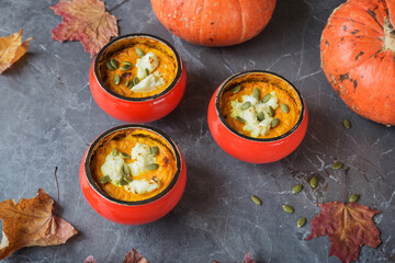 Homemade autumn pumpkin souffle with cream cheese and seeds on dark table with maple leaves and pumpkin. Thanksgiving Day.  Autumn composition. Healthy food concept.