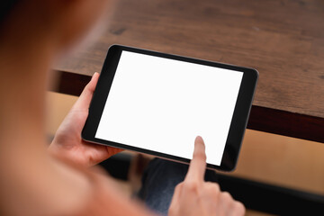 Mock up of woman hand holding digital tablet and touching blank screen.