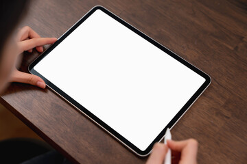 Mock up of woman hand holding digital tablet and touching blank screen.