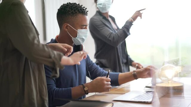 Coworkers in open space office, protected with plexiglas during 19-ncov pandemic