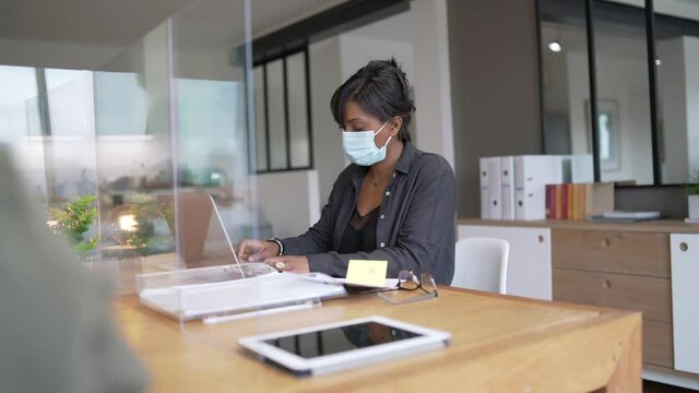 Office worker wearing surgical face mask in open space area