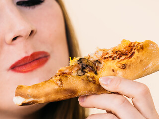 Woman eating hot pizza slice