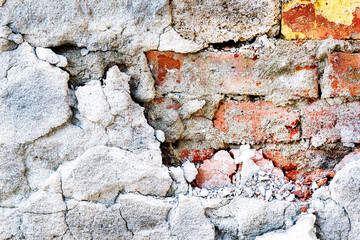 Vintage brick rough rustic wall with cracked plaster.Texture of old brick wall with peeling plaster. Beautiful background of old brickwork of the historic building.