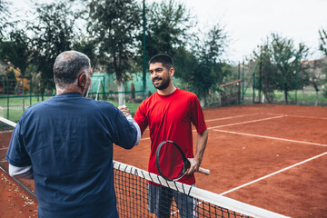Obraz premium middle aged father with his son on tennis court