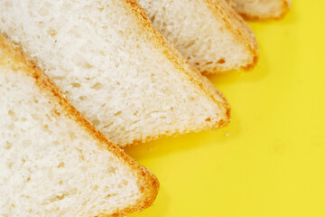 Sliced white bread on yellow background, top view