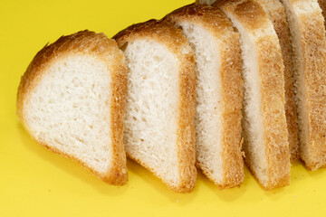 Sliced white bread on yellow background, top view