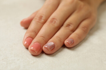 Female hand with pink nails on white background, close up