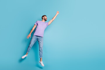 Full length body size photo of jumping man pretending superhero superpower flying high isolated on vibrant blue color background