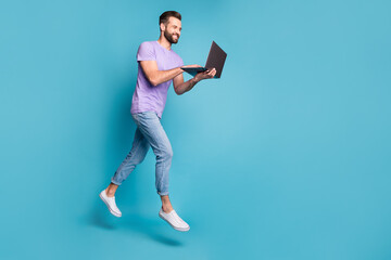 Full length body size photo of cheerful jumping man working on laptop doing project isolated on...