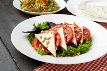Salad with fresh tomatoes and brined cheese, sunflower seeds on top
