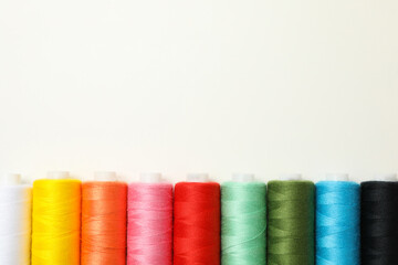 Color sewing threads on white background, space for text