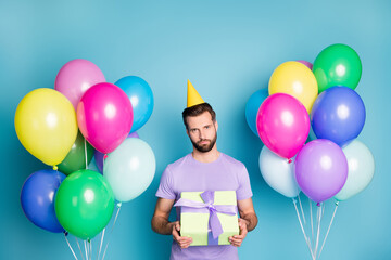 Photo portrait of indifferent guy holding gift box nobody came to party isolated on pastel blue...