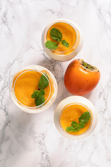 Three glasses with persimmon mousse dessert.