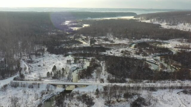 Aerial video of Koen river and bridge under ice and snow. Beautiful winter landscape
