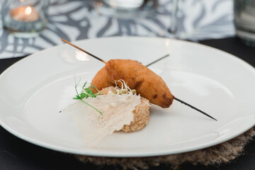chef serving juicy meat cutlets with a crisp on a ceramic plate with rice