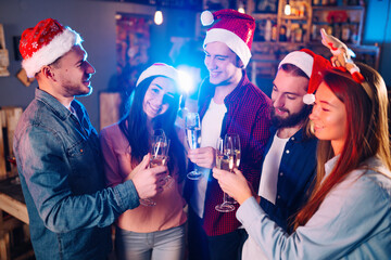 Group of happy friends celebrating  new year's party.  A crowd of young  people with sparklers, gifts and clinking glass. Party, holidays,  nightlife, holidays. Christmas.