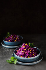 Fresh vegetarian salad with red cabbage and corn on a dark background, copy space