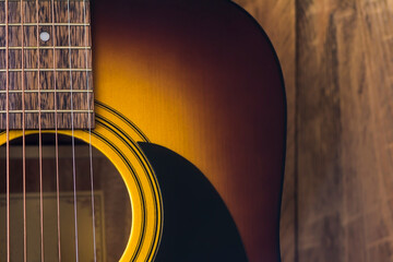 Naklejka premium Acoustic guitar on a wooden background.
