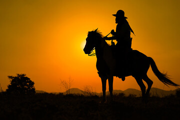 Silhouette Cowboy on horseback. Ranch