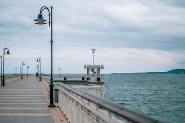 Sea bridge in Burgas, Bulgaria in winter autumn season. Grey white sky, gloomy day.