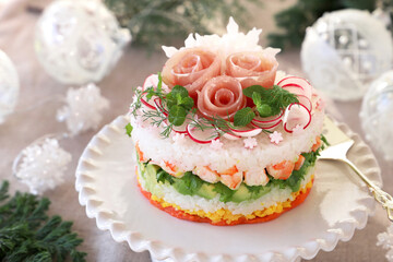 Christmas layered salad with salmon, avocado, shrimp, and vinegared rice on holiday decoration table.　ケーキ寿司　クリスマス