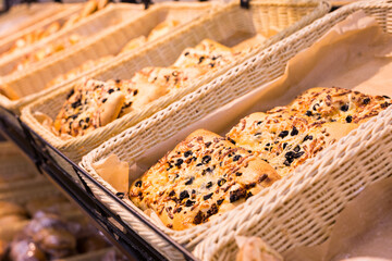 rectangular pizza with cheese and olives on a bakery counter