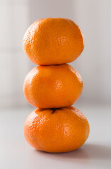 tower of three mandarines on white background
